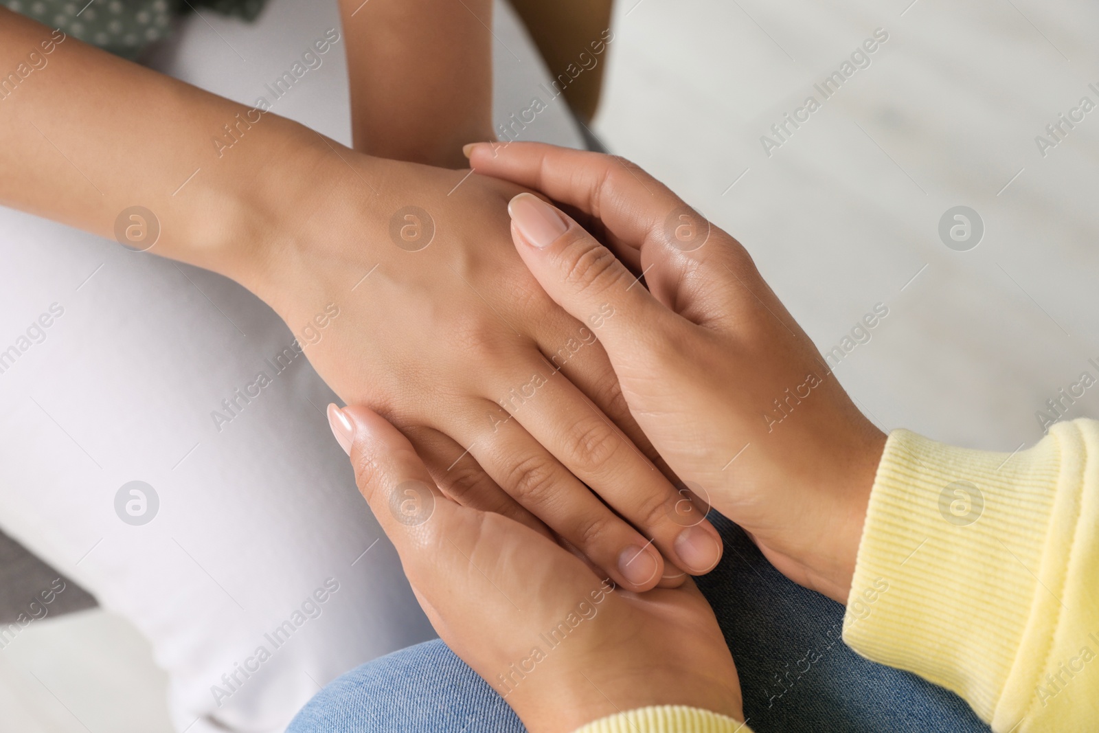 Photo of Psychotherapist holding patient's hand in office, closeup