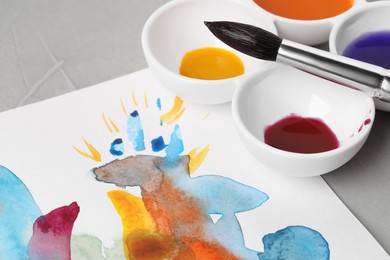 Abstract watercolor painting, colorful paints and brush on grey table, closeup