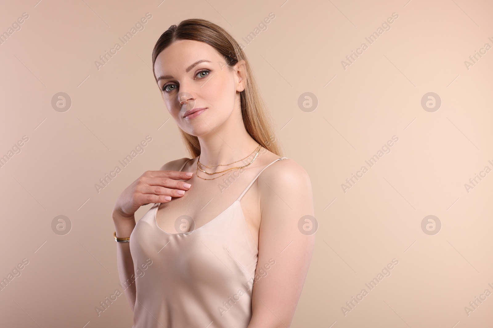 Photo of Beautiful woman with elegant jewelry on beige background. Space for text