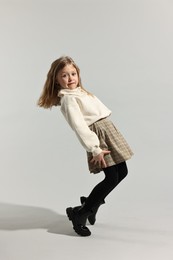 Photo of Fashion concept. Stylish girl posing on light grey background