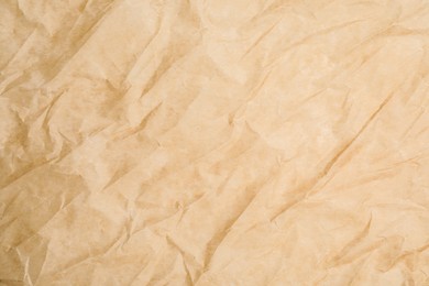 Photo of Texture of crumpled brown baking paper as background, closeup
