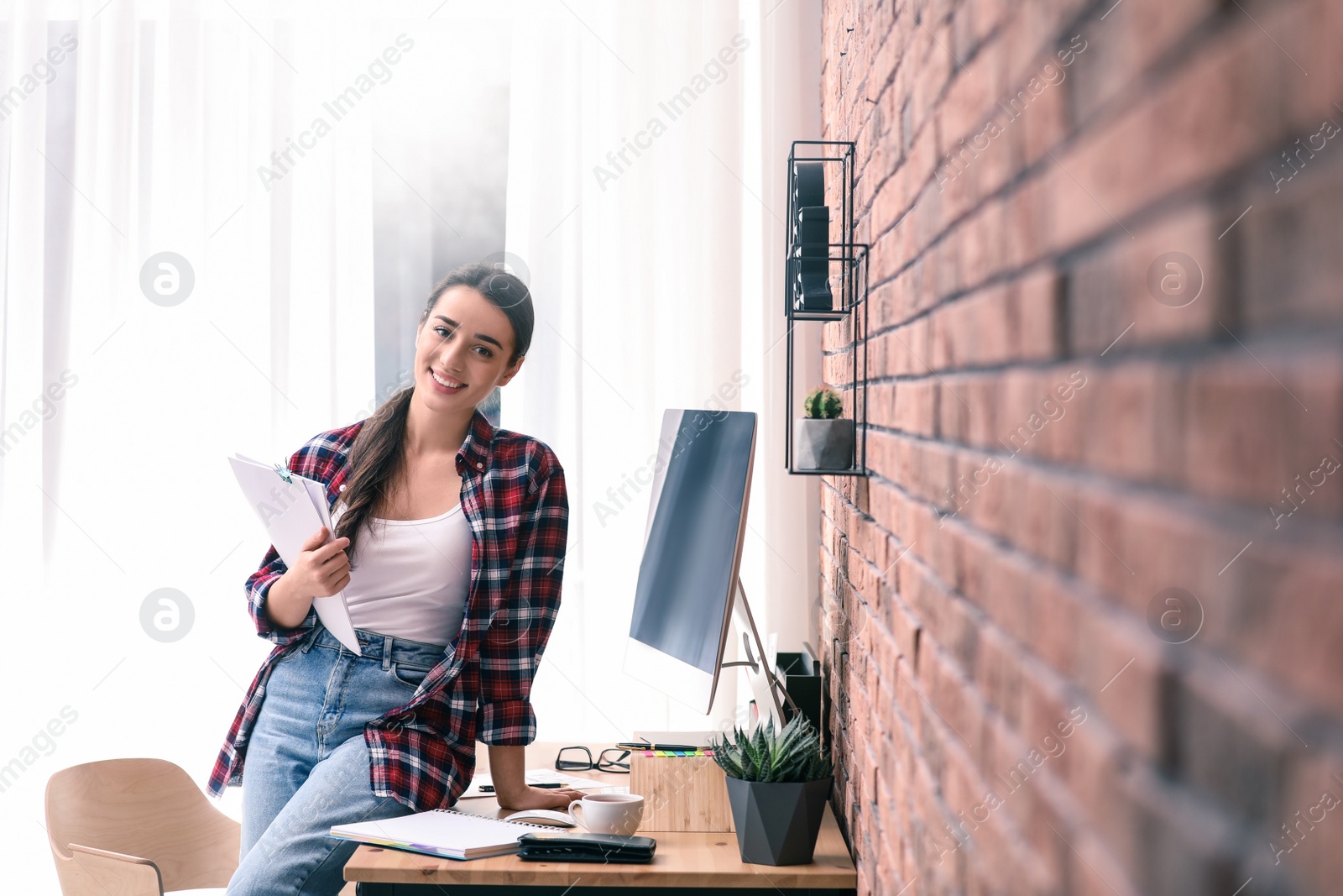 Image of Professional journalist with papers at workplace in light office