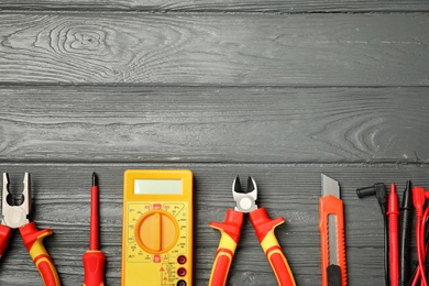 Flat lay composition with electrician's tools and space for text on wooden background