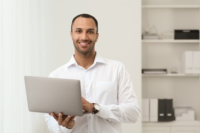 Handsome young man with laptop at home