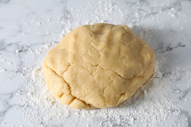 Making shortcrust pastry. Raw dough and flour on white marble table