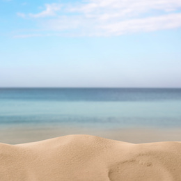 Beautiful beach with golden sand near sea, closeup view