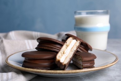 Photo of Tasty choco pies and milk on grey table