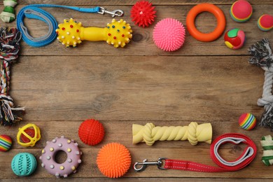 Flat lay composition with dog leashes and toys on wooden background, space for text