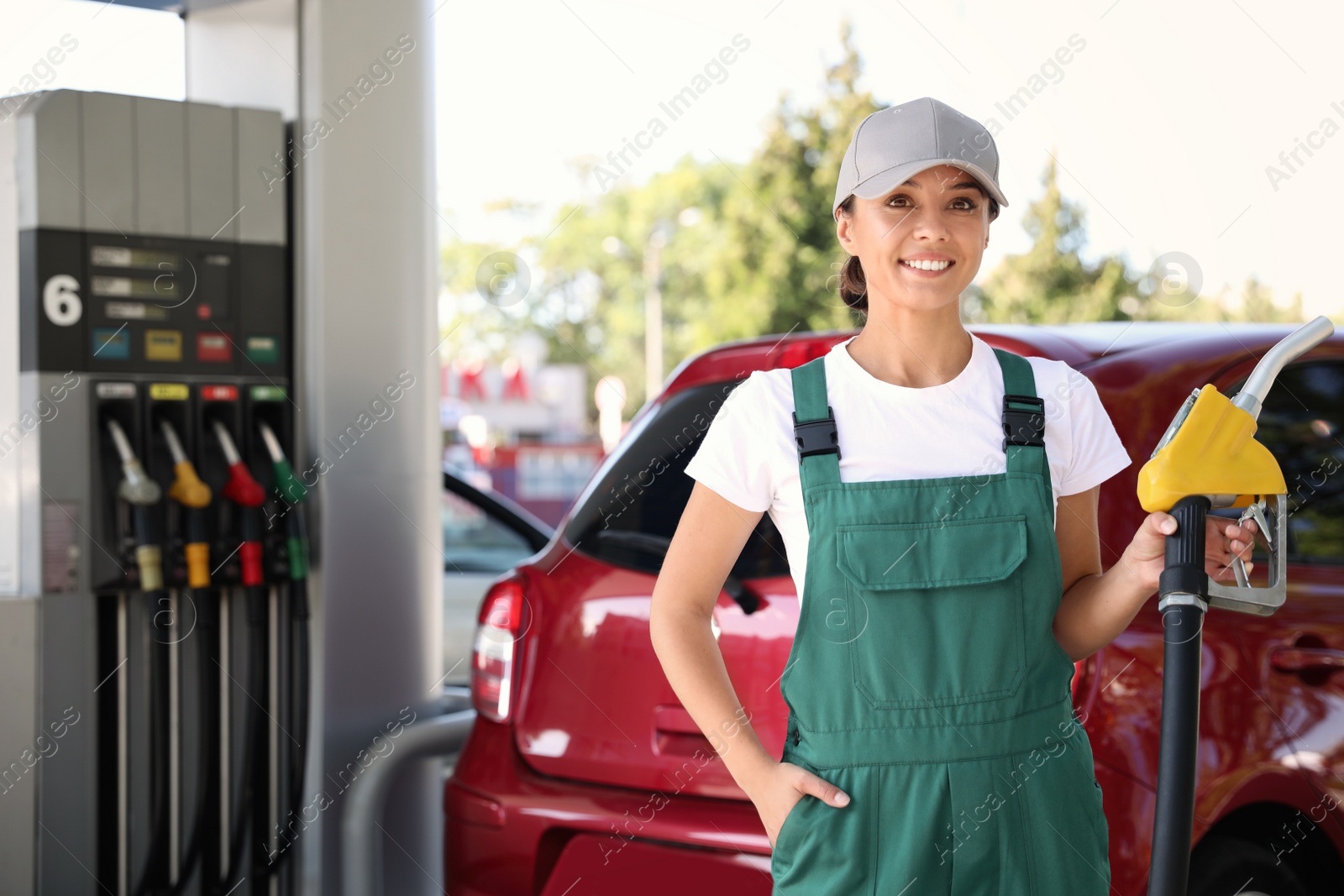 Photo of Worker with fuel pump nozzle at modern gas station