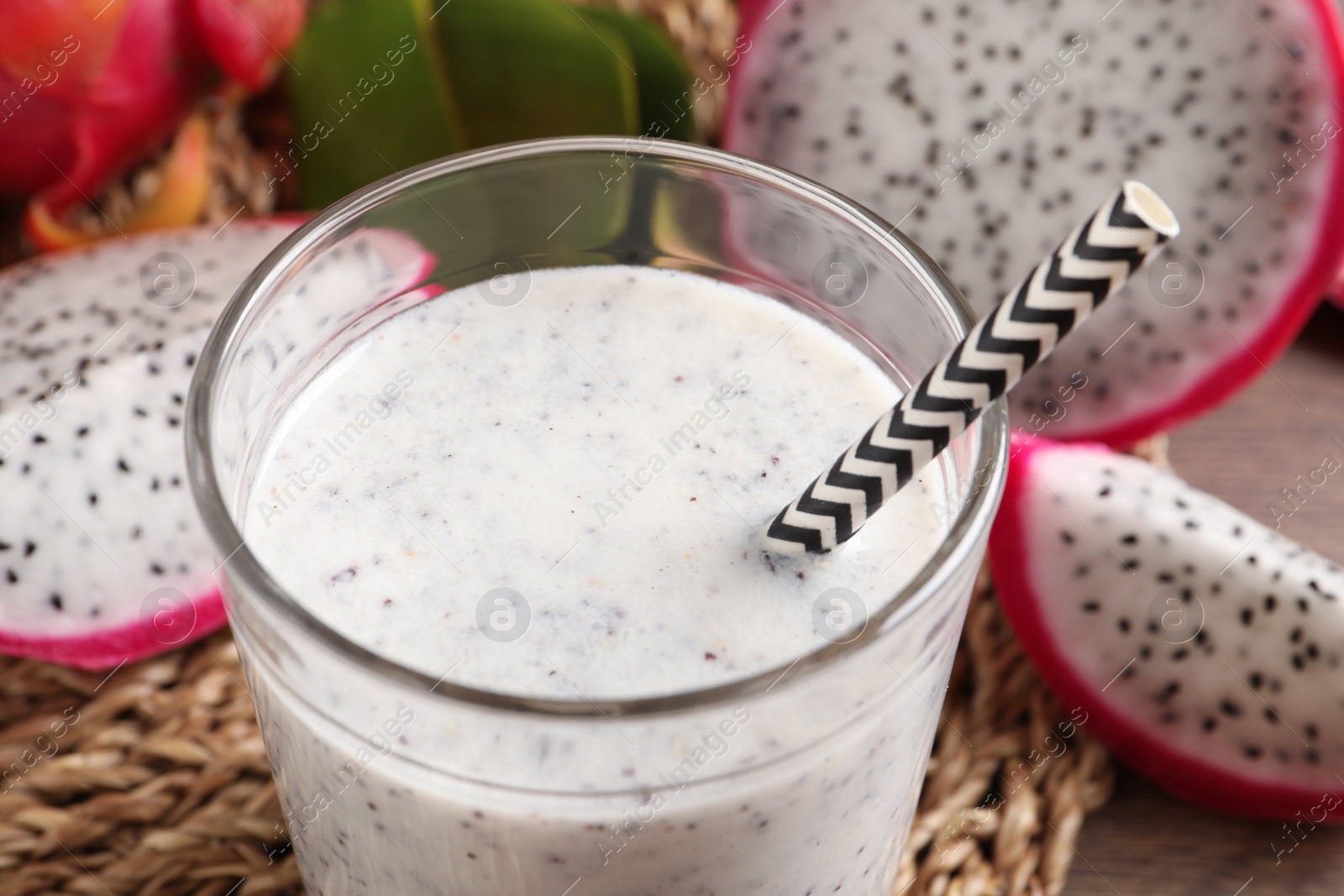 Photo of Delicious pitahaya smoothie and fresh fruits on table, closeup