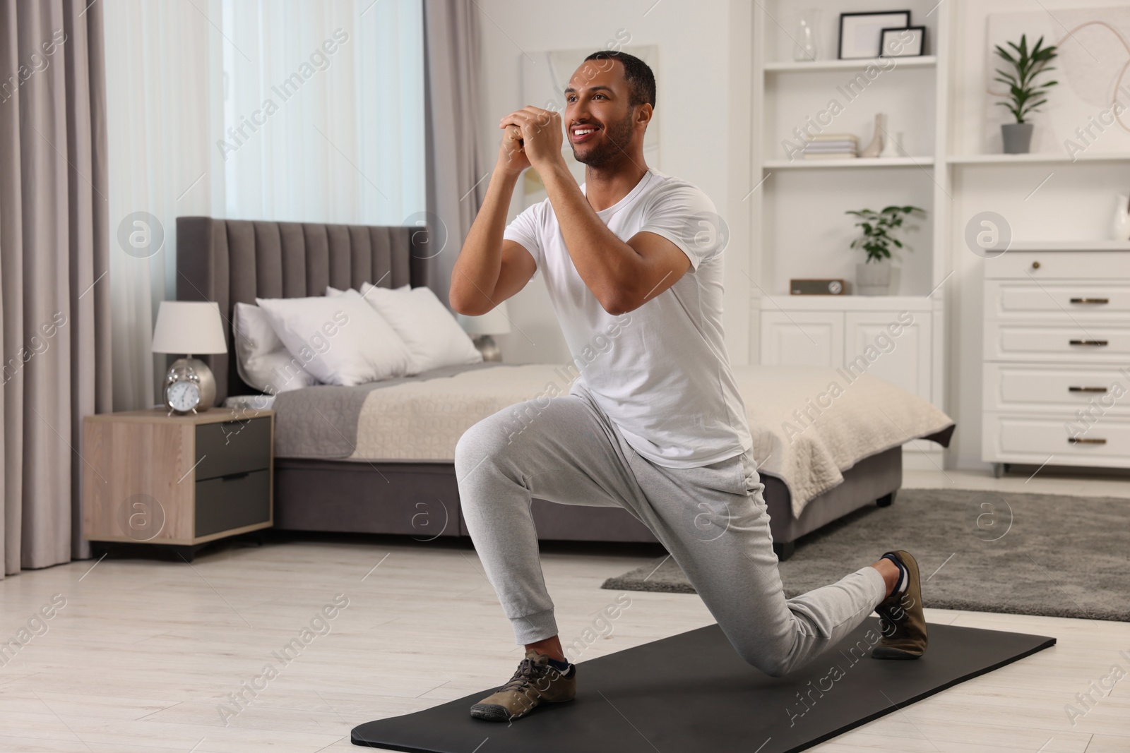 Photo of Man doing morning exercise on fitness mat at home