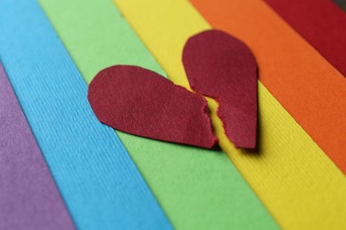 Photo of Halves of torn paper heart on colorful background. Breakup concept