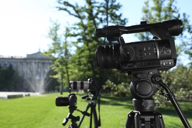 Photo of Modern video cameras in park. Professional media equipment