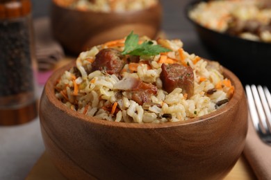 Photo of Delicious pilaf with meat and carrot in bowl on table, closeup