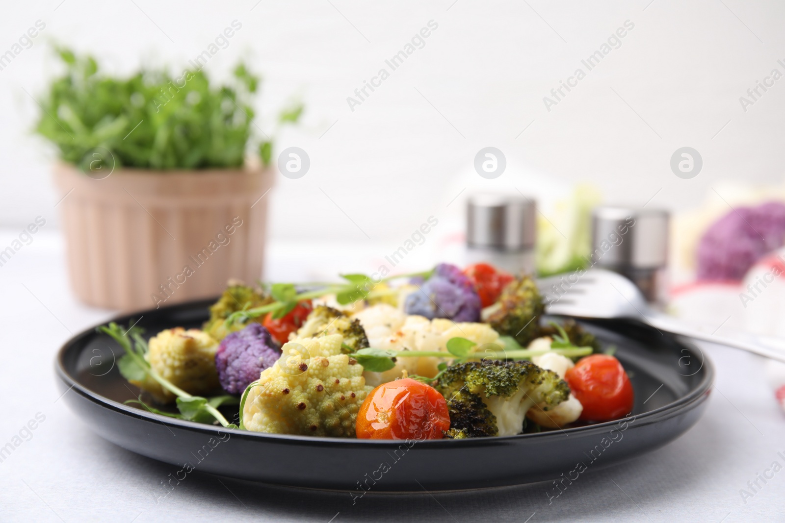 Photo of Delicious salad with cauliflower and tomato served on white table, closeup