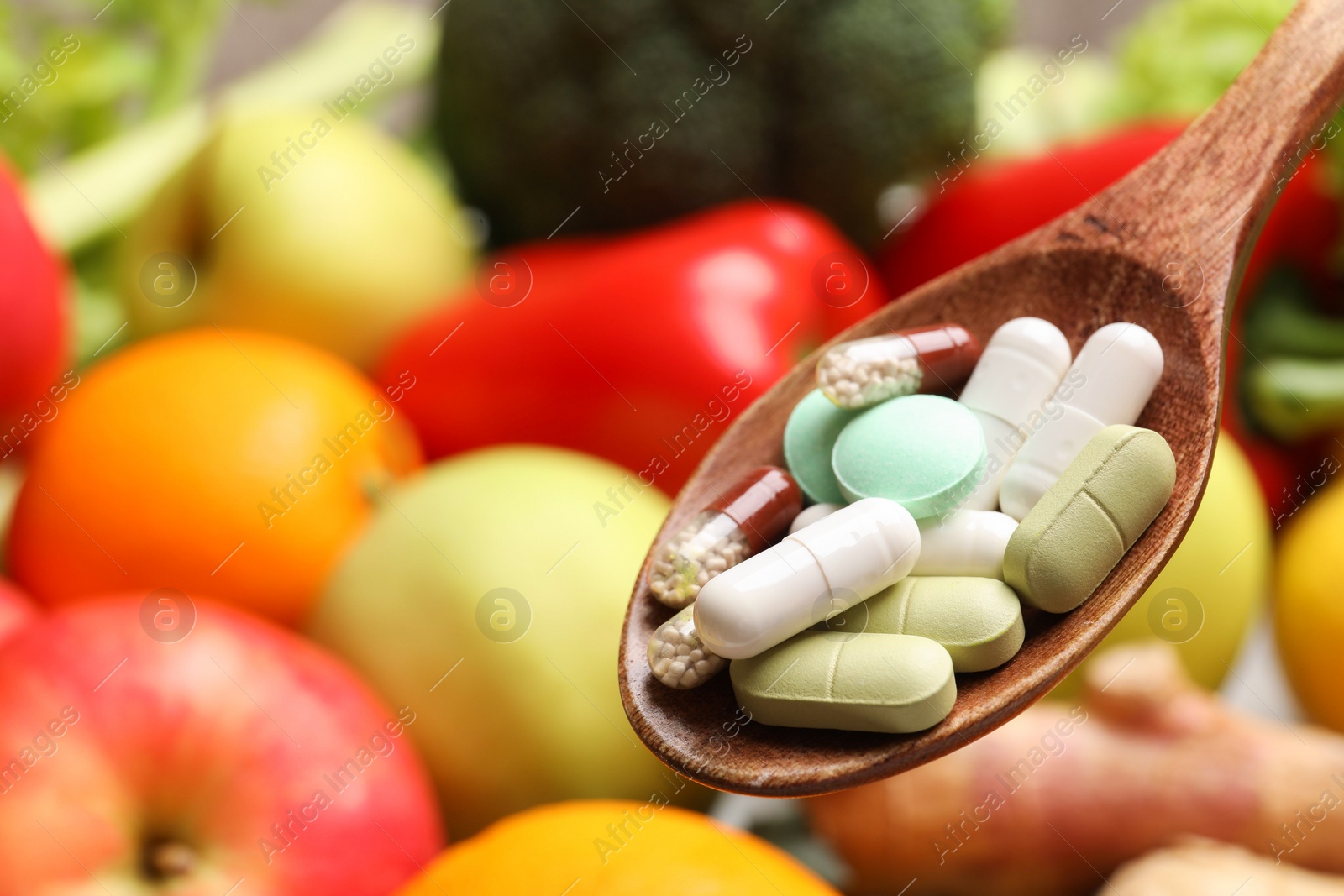 Photo of Different dietary supplements in wooden spoon near products, closeup. Space for text