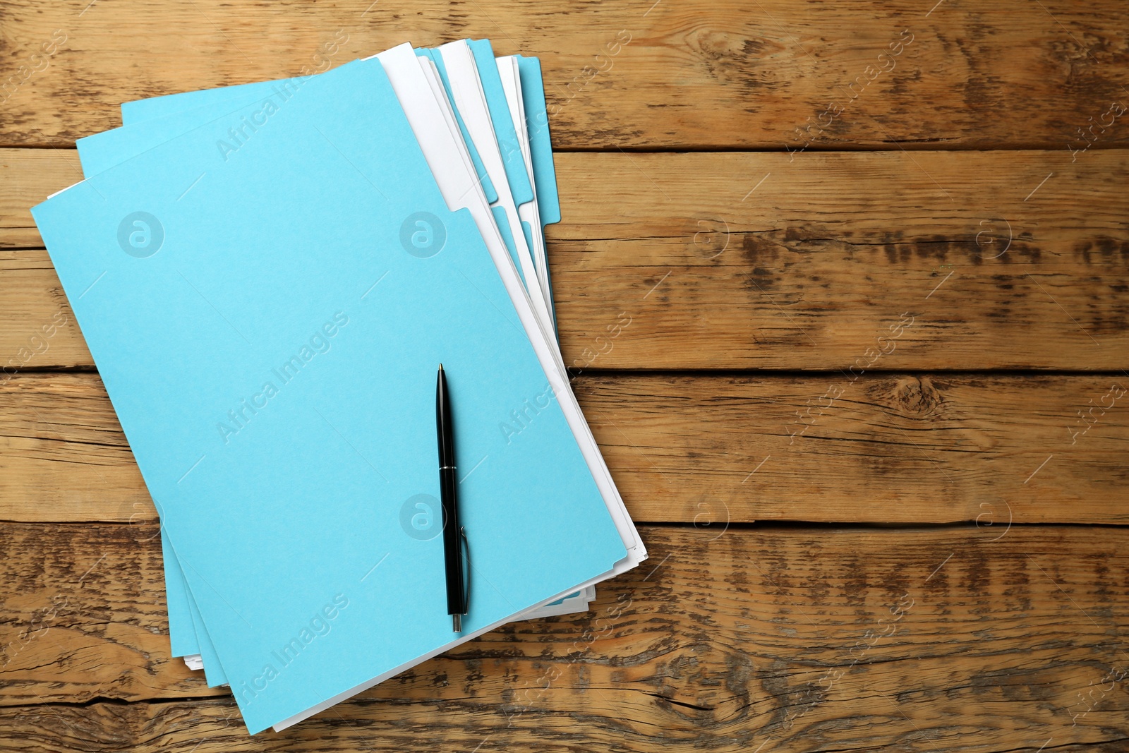 Photo of Turquoise files with documents and pen on wooden table, top view. Space for text