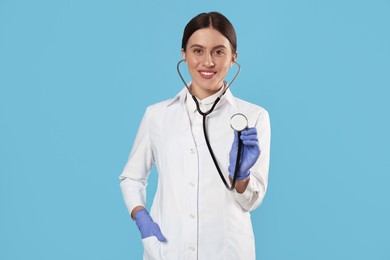 Photo of Doctor with stethoscope on light blue background. Cardiology concept