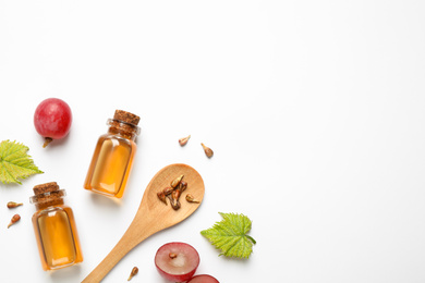 Photo of Composition with bottles of natural grape seed oil on white background, top view. Organic cosmetic