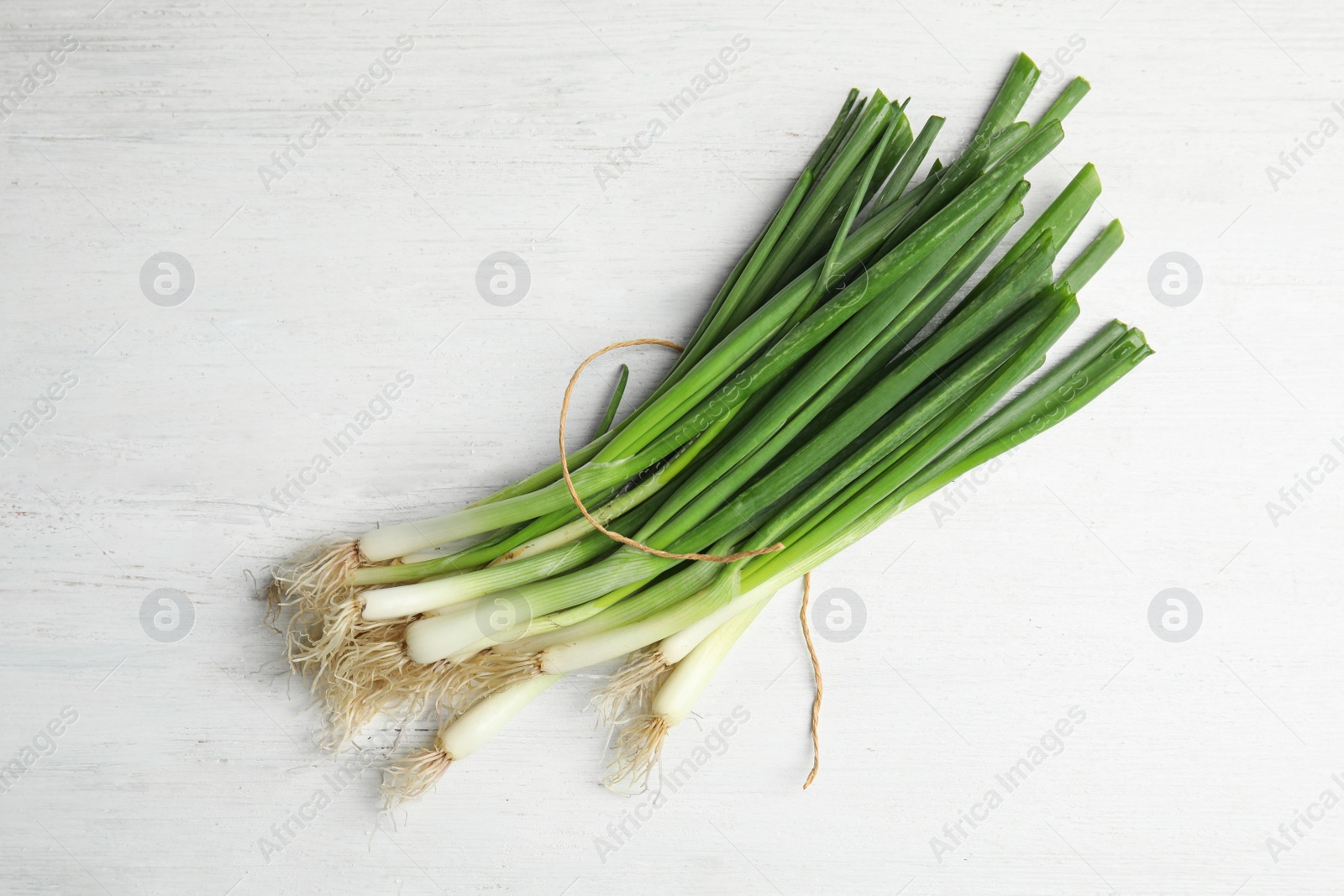 Photo of Fresh green onion on wooden table, top view