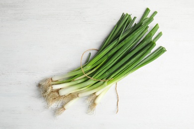 Photo of Fresh green onion on wooden table, top view