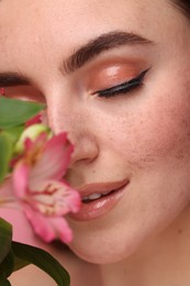 Beautiful woman with fake freckles and flower, closeup