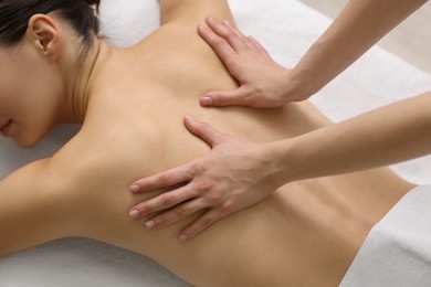 Photo of Woman receiving back massage on couch in spa salon, above view