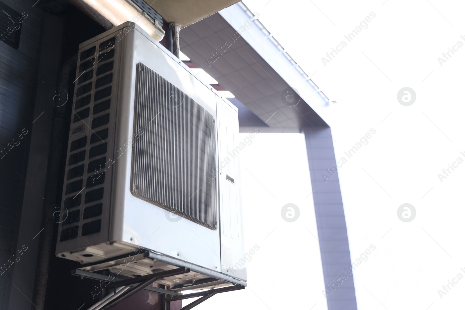 Photo of Air conditioner on wall of building. Space for text