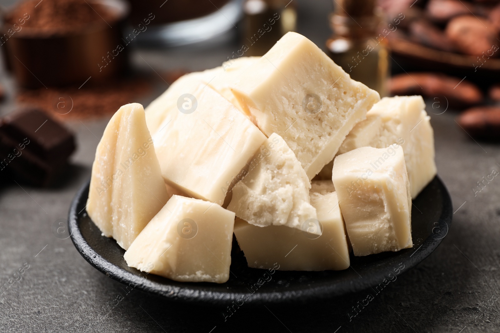 Photo of Organic cocoa butter on grey table, closeup