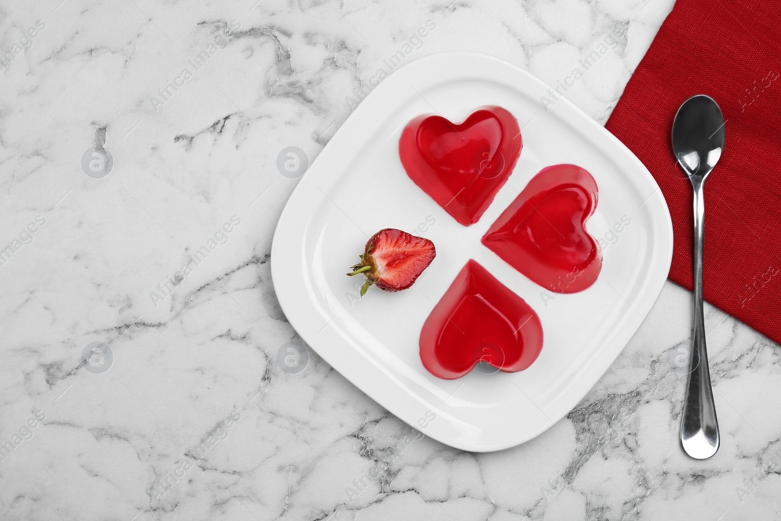 Photo of Plate of tasty strawberry jelly served on marble table, flat lay with space for text