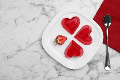 Photo of Plate of tasty strawberry jelly served on marble table, flat lay with space for text