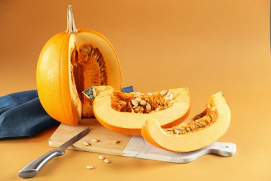 Photo of Cut fresh ripe pumpkin on orange background