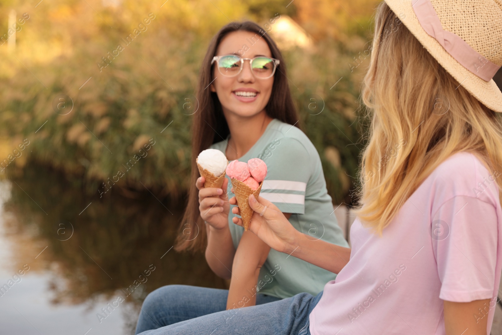 Photo of Young women with ice cream spending time together outdoors