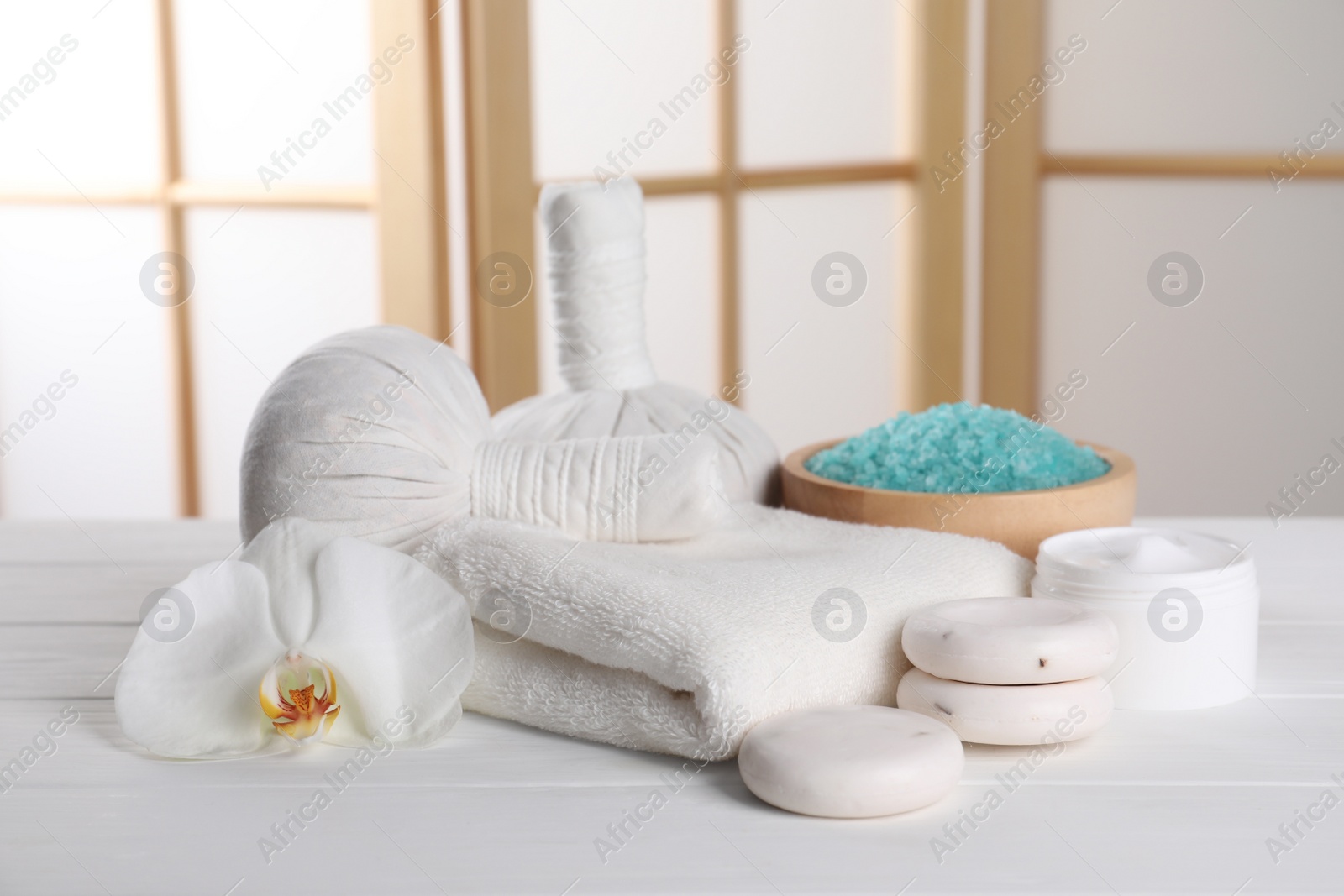 Photo of Spa composition with care products on white wooden table in room