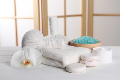 Photo of Spa composition with care products on white wooden table in room