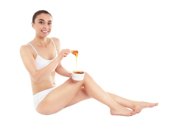 Photo of Young woman holding hot wax isolated on white. Epilation procedure