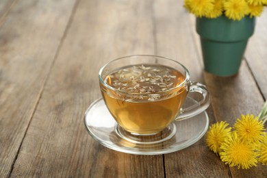 Delicious fresh dandelion tea on wooden table