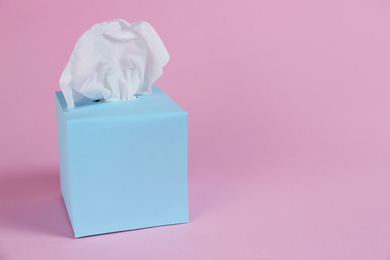 Photo of Box with paper tissues on pink background. Space for text