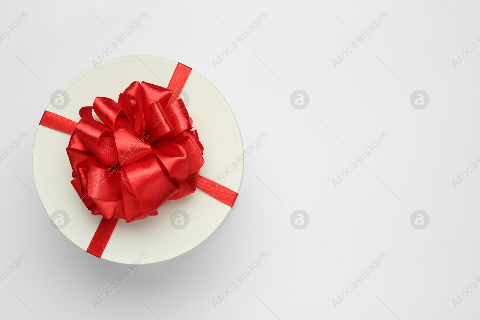 Photo of Gift box with red bow on white background, top view