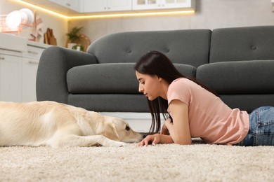 Photo of Woman with cute Labrador Retriever dog on floor at home. Adorable pet