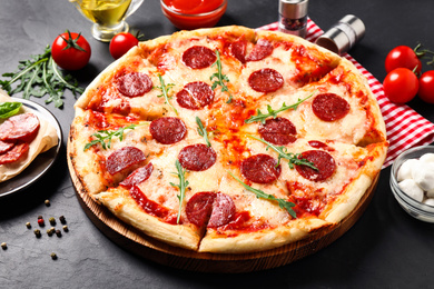 Photo of Hot delicious pepperoni pizza on dark table