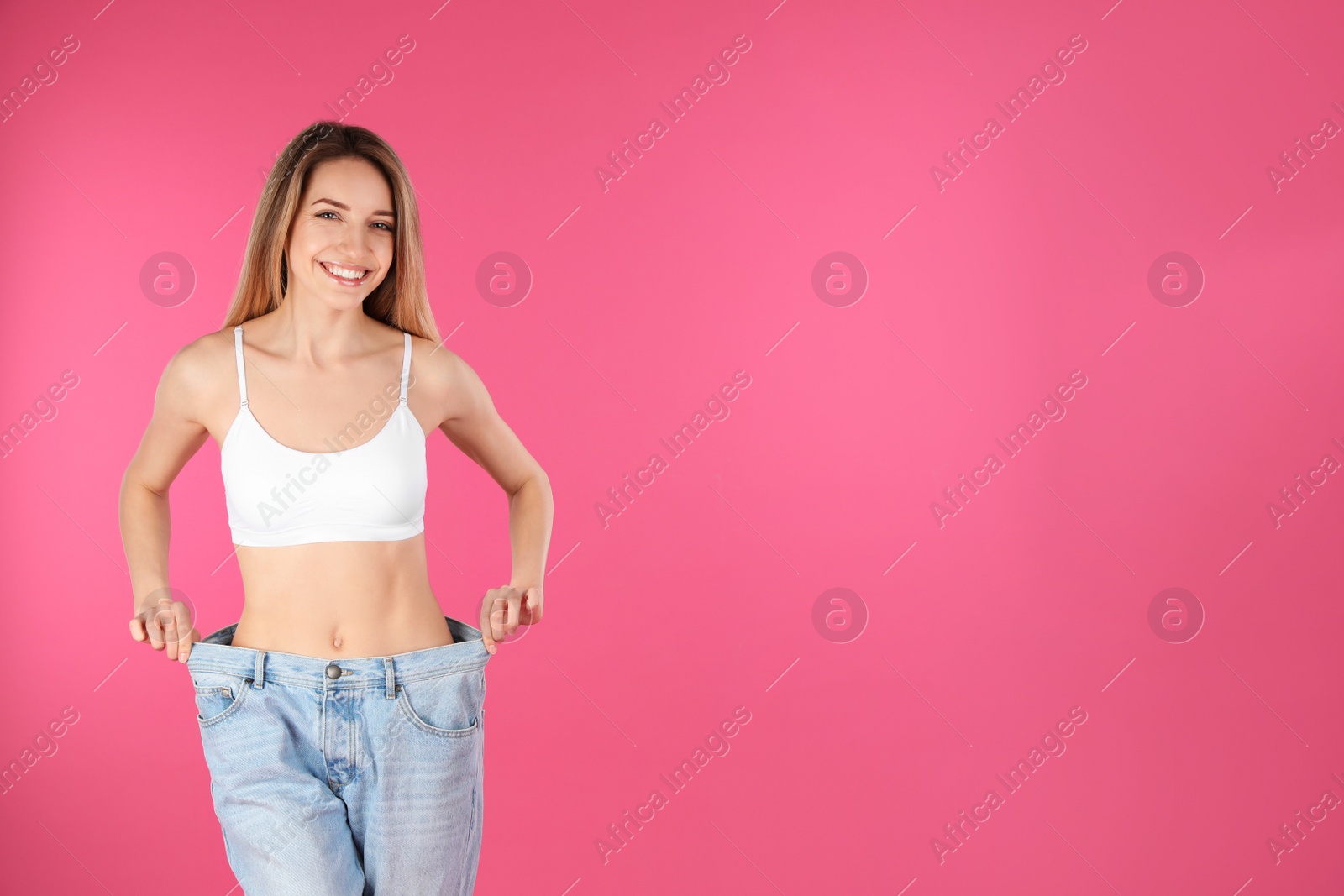 Photo of Slim woman in oversized jeans on color background, space for text. Perfect body