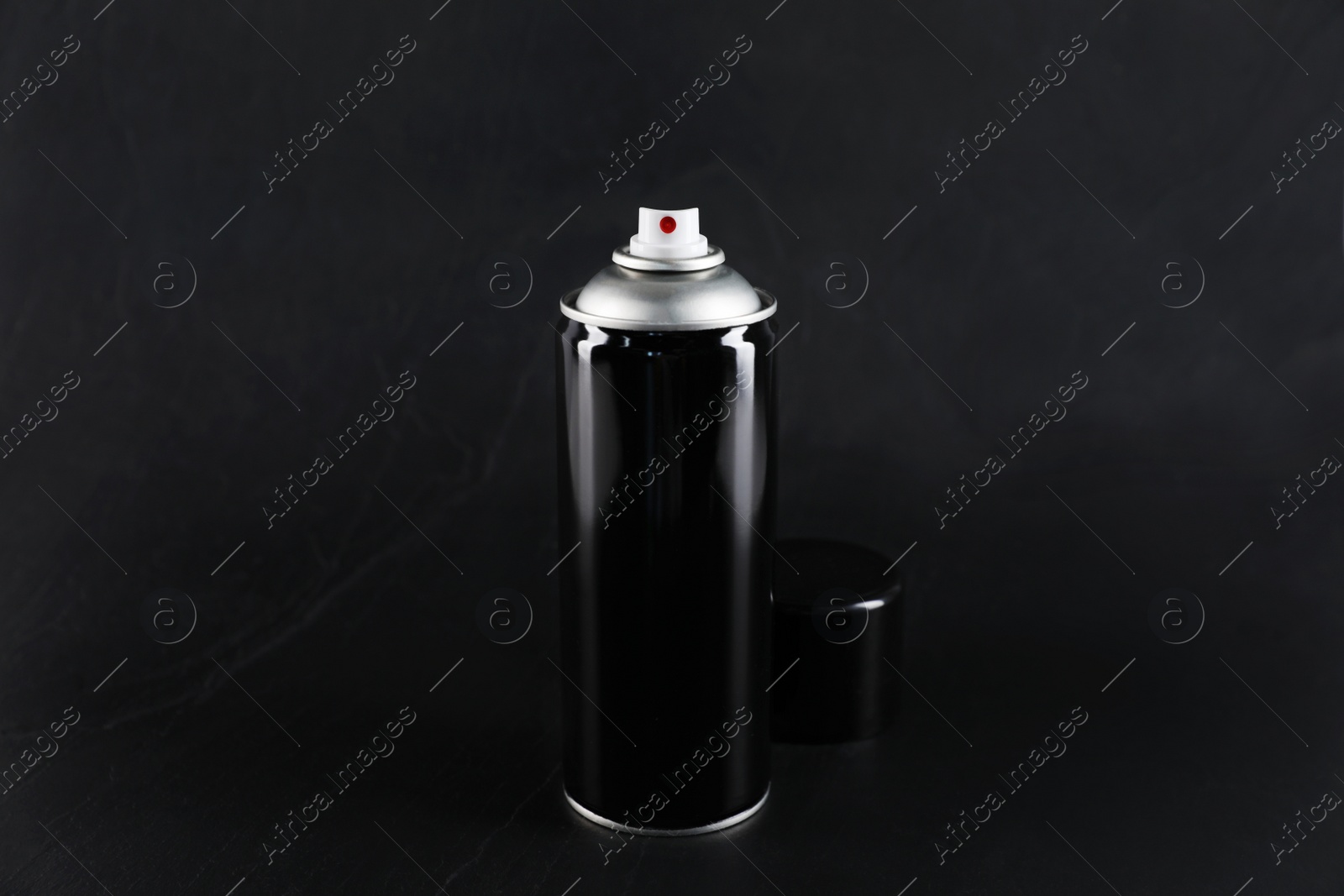 Photo of Can of spray paint on black background
