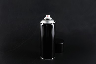 Photo of Can of spray paint on black background