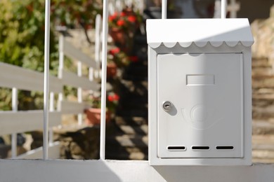 Photo of White metal letter box on fence outdoors