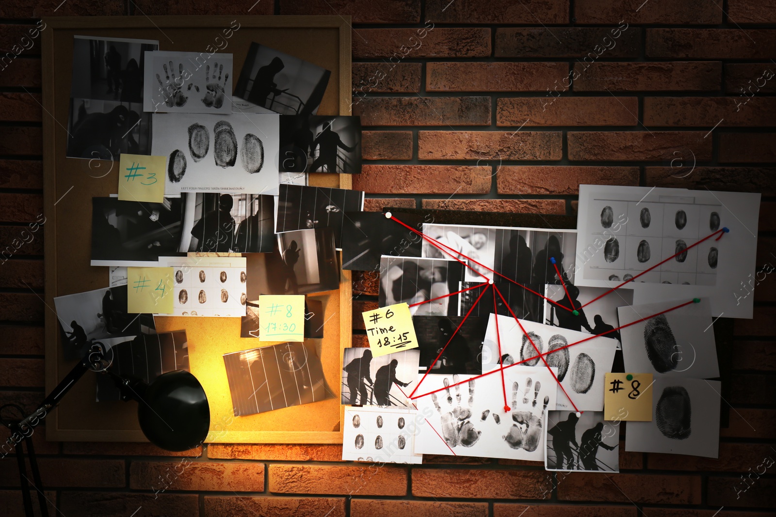 Photo of Boards with fingerprints, crime scene photos and red threads on brick wall. Detective agency