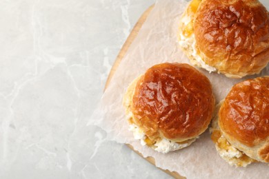 Photo of Freshly baked soda water scones with jam and butter on light grey marble table, top view. Space for text