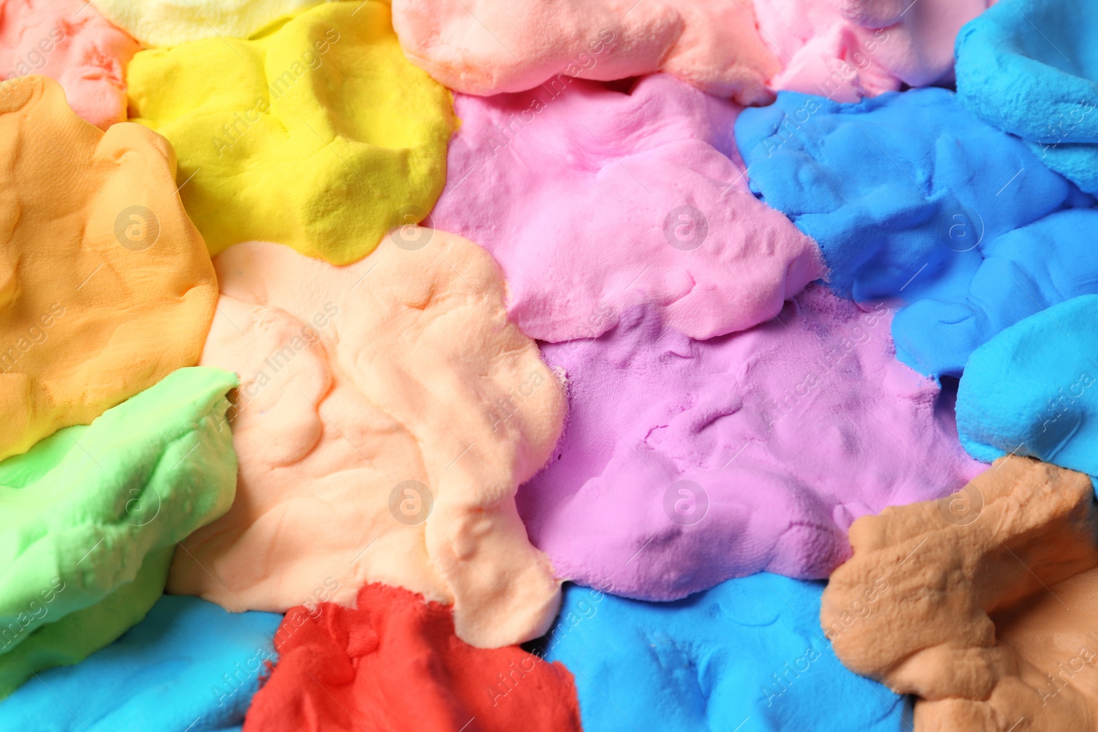 Photo of Different color play dough as background, closeup