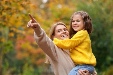 Photo of Happy mother with her daughter in autumn park. Space for text