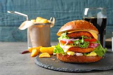 Photo of Slate plate with double vegetarian burger on table. Space for text